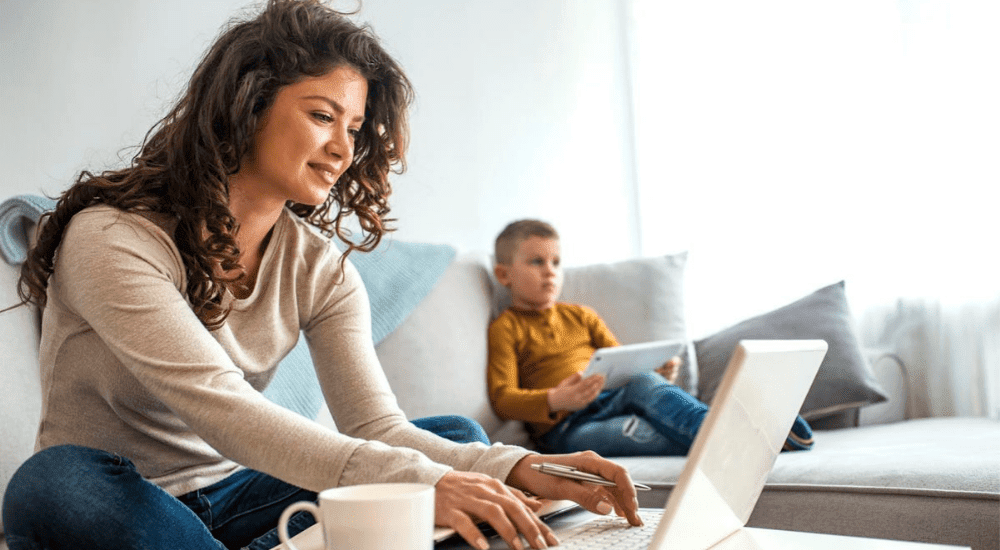 A lady catching up on emails while her sons stream movies on their uncapped fibre connection