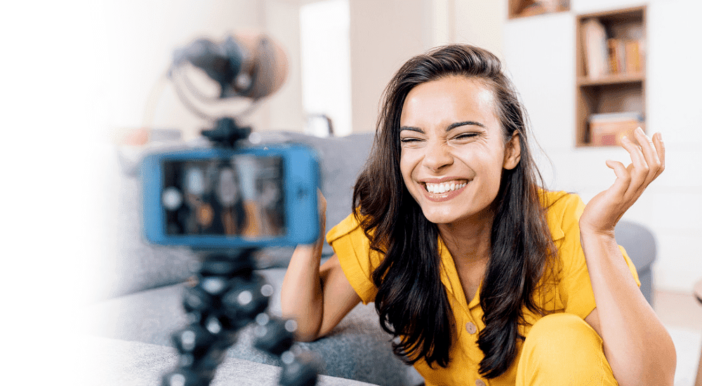 A woman filming live on social media with lightning-fast Vox TT Connect fibre 