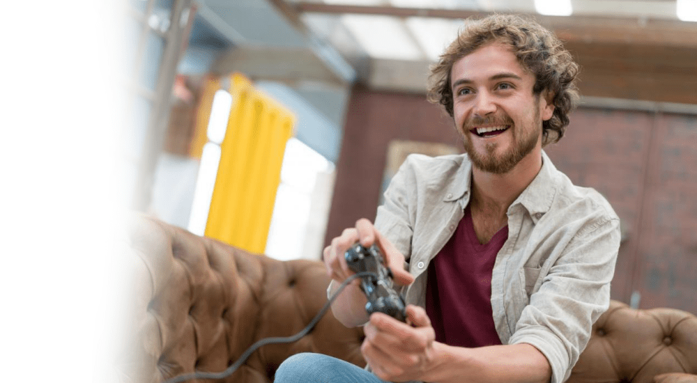 A man playing video games connected to his home fibre connection