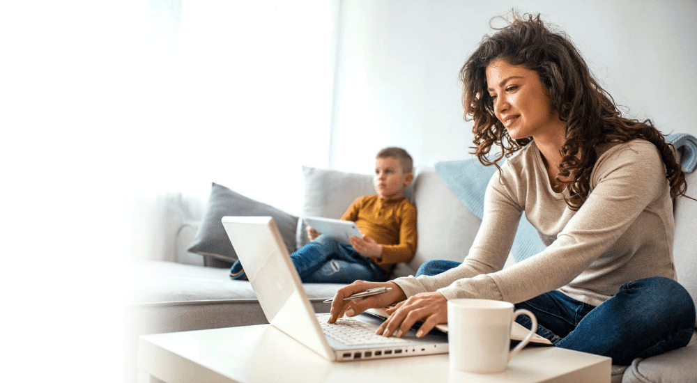 A lady catching up on emails while her sons stream movies on their uncapped fibre connection