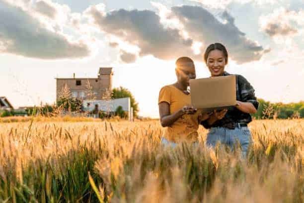 Friends browsing on their laptops outdoors with a reliable Eutelsat internet connection in South Africa