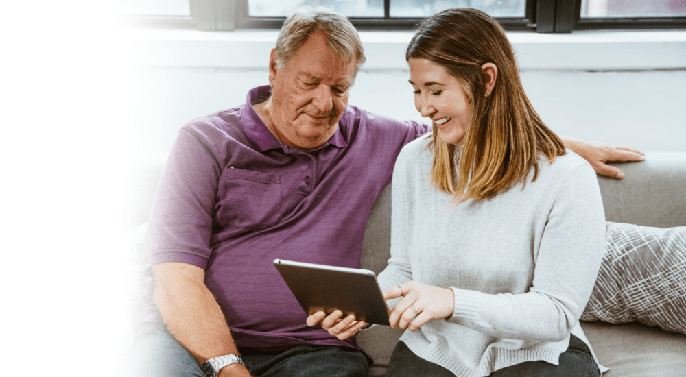 A young girl showing her father how to use social media with their Vox Frogfoot Fibre internet connection