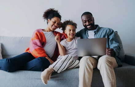 Family sitting on the couch watching movies with fast and reliable Vox Octotel fibre internet