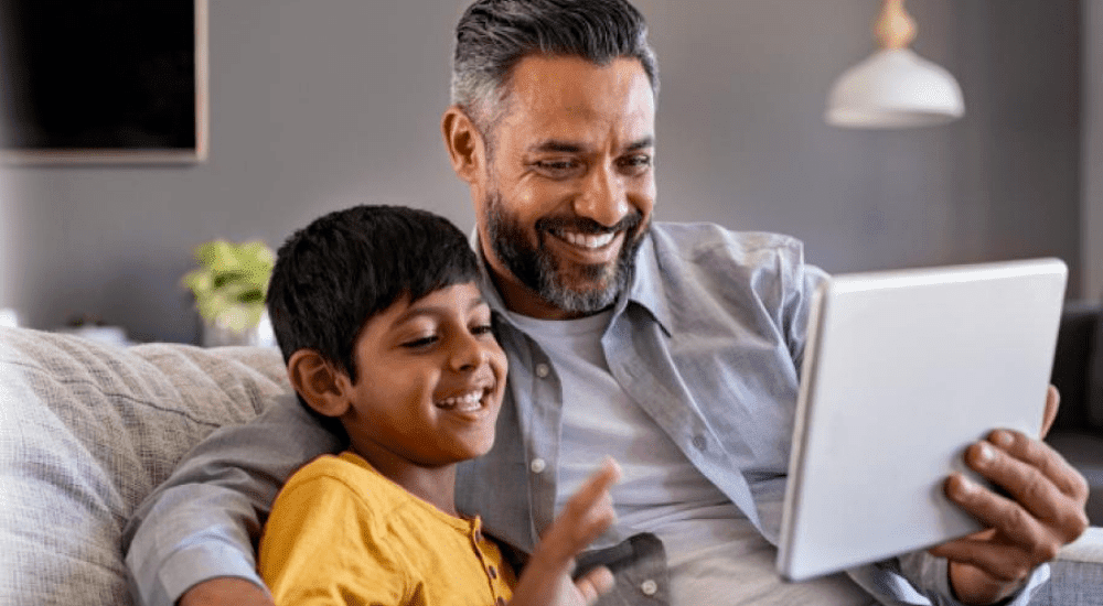 A father and son on a video chat using their Zoom fibre internet connection