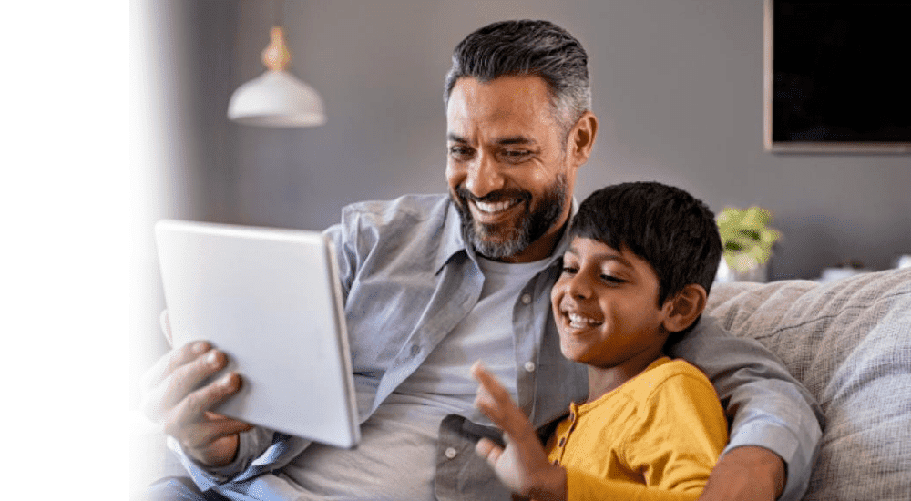 A father and son on a video chat using their Zoom fibre internet connection