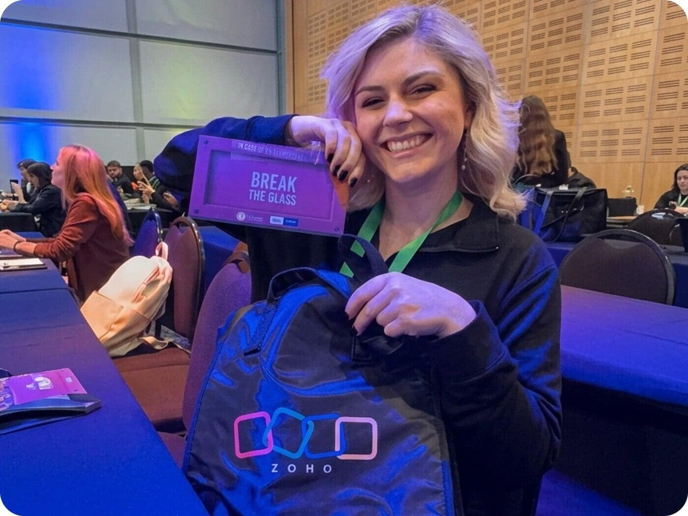 DSL Telecom's Emily holding her Zoho goodie bag and a Break the Glass card at Zoholics Cape Town 2026