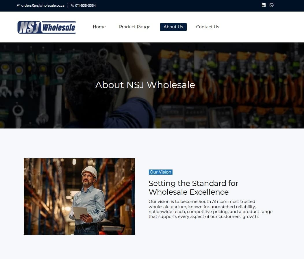 NSJ Wholesale team member using a tablet on the warehouse floor, surrounded by stocked shelving