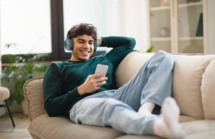 Teenager streaming music on the couch with fast and dependable Vox Frogfoot internet